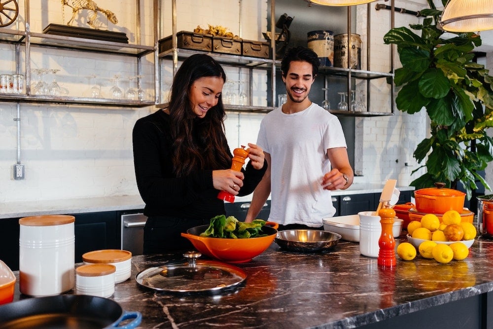 A man and a woman cooking in a kitchen