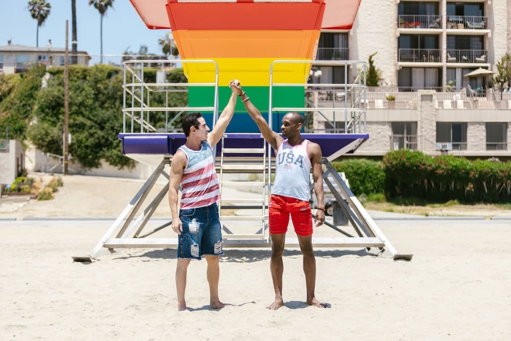 couple on beach infront of pride symbol