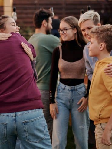 People hugging at an outdoor gathering