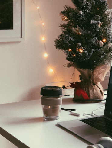 Laptop and small Christmas tree on a desk